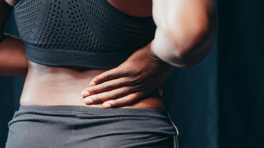 Lower back pain - woman holding her back<br />
